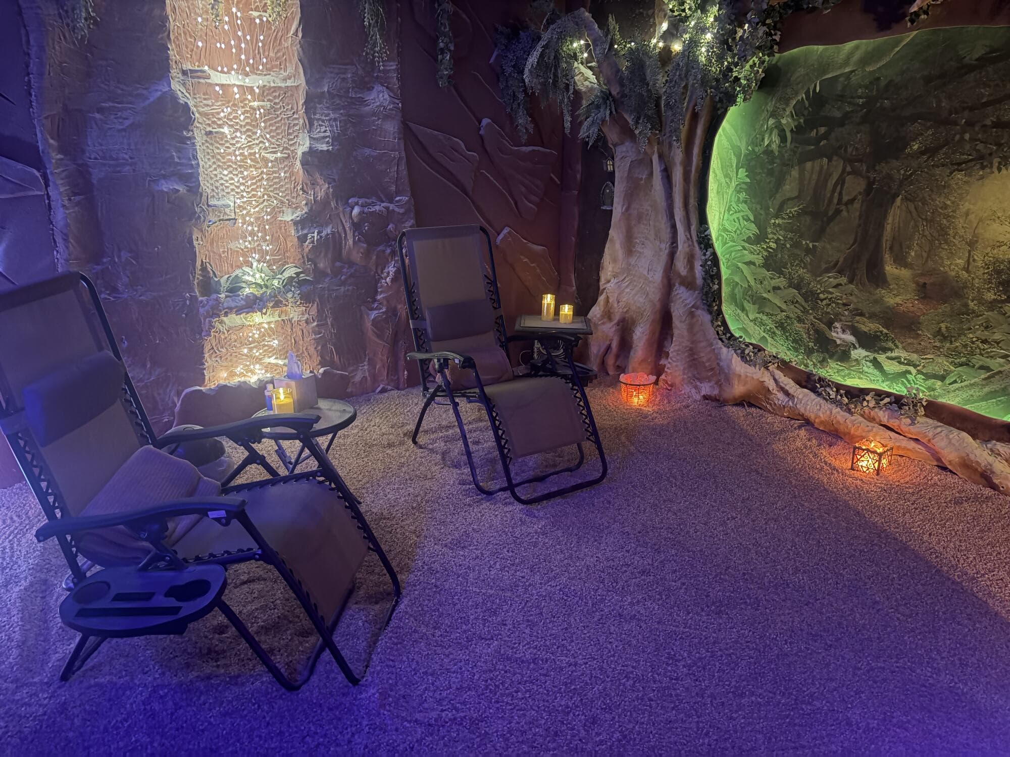 The enchanted forest mural and salt-lamp glow inside the cave